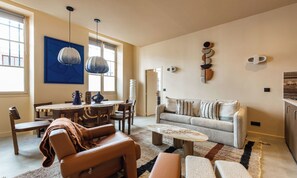 Un salon comprenant un canapé, une table basse et un coin repas avec des chaises et une table.