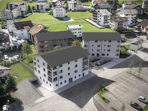 A multi-story residential building with a parking area in front. - Residenza Grava Appartement/Fewo, Dusche, WC, 1 Schlafraum by Interhome (Savognin)