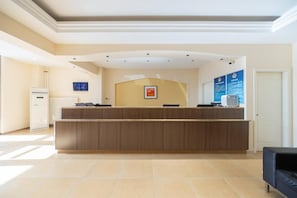 A reception desk in a hotel lobby with a tiled floor and a radiator. - Homeinn (Beijing)