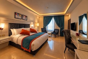 A hotel room with a large bed, bedside tables, a desk, a chair, a TV, and a window with curtains. - Petra Canyon Hotel Petra (Wadi Musa)