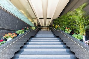 Eine moderne Treppe, gesäumt von Kübelpflanzen und Blumen.