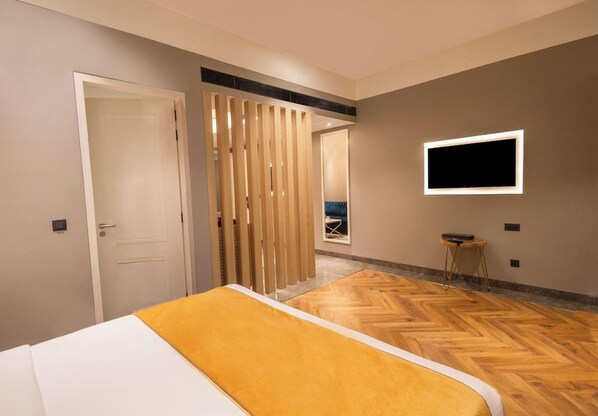 A hotel room with a bed, a TV mounted on the wall, and a view of the outside. - Polo Hotels, Agartala (Agartala)