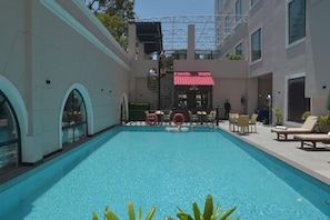 Piscina con sillones de descanso y zona de bar.