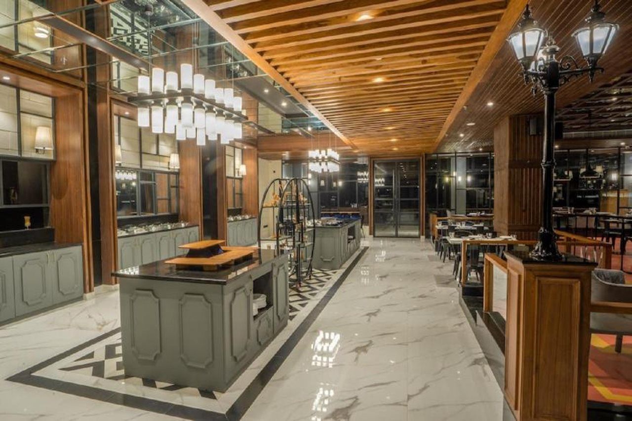 A modern interior with a central island, wooden ceiling, and glass walls.