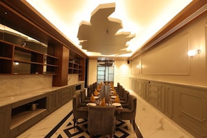 A long dining table with multiple chairs, a modern ceiling design, and a marble floor. - Polo Hotels, Agartala (Agartala)