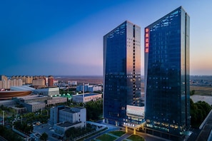 A high-rise hotel with a prominent entrance and a view of the surrounding cityscape. - Ramada by Wyndham Khorgos Free Trade Zone (Lianyungang)