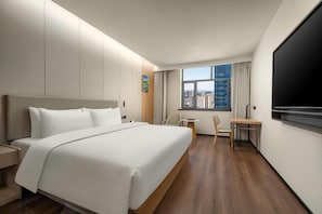 A hotel room with a large bed, a desk, a chair, and a TV. - Ramada by Wyndham Khorgos Free Trade Zone (Lianyungang)