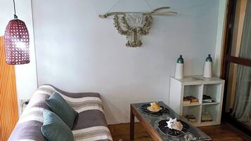 Ein gemütliches Zimmer mit einem Bett, einem kleinen Tisch und einer Wanddekoration.