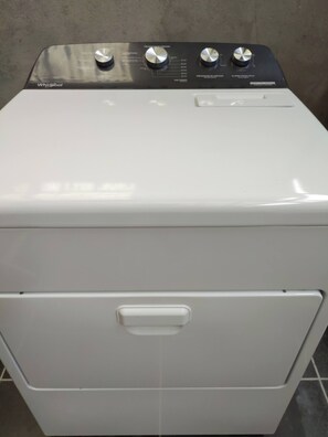 Une machine à laver Whirlpool à chargement frontal, dotée d’un panneau de commande avec plusieurs boutons.