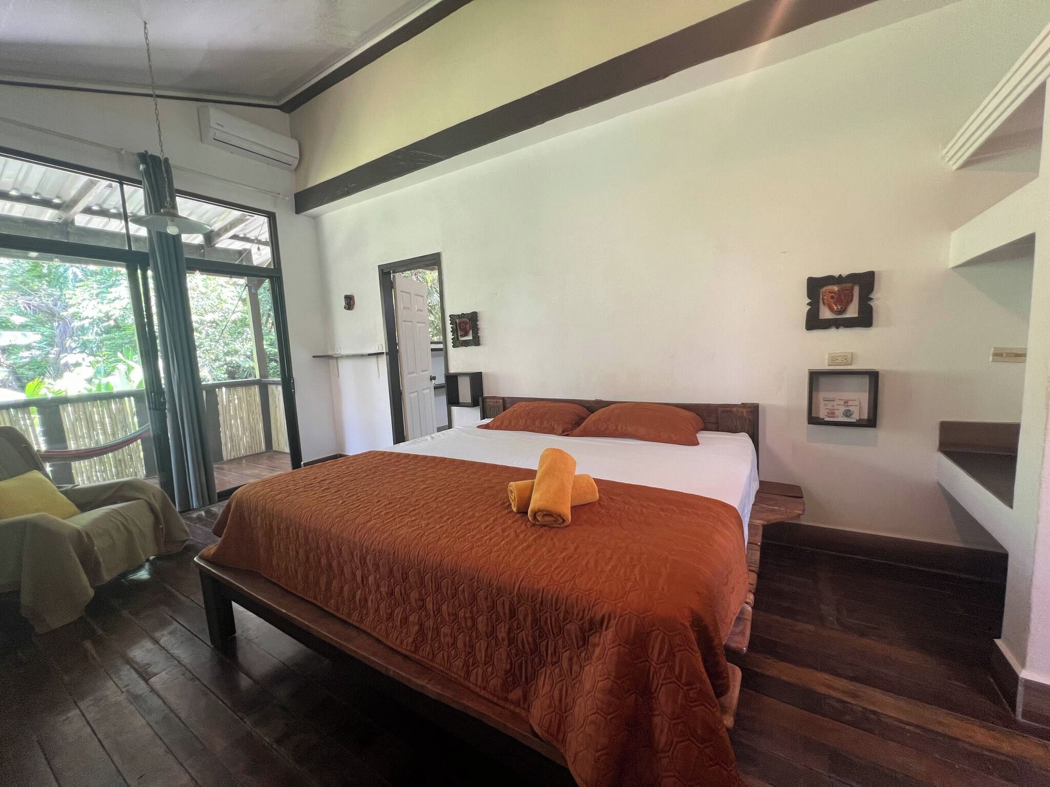 Una habitación con una cama, una silla y una ventana.