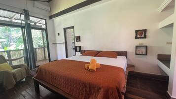 Una habitación con una cama, una silla y una ventana.