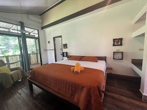 Una habitación con una cama, una silla y una ventana.