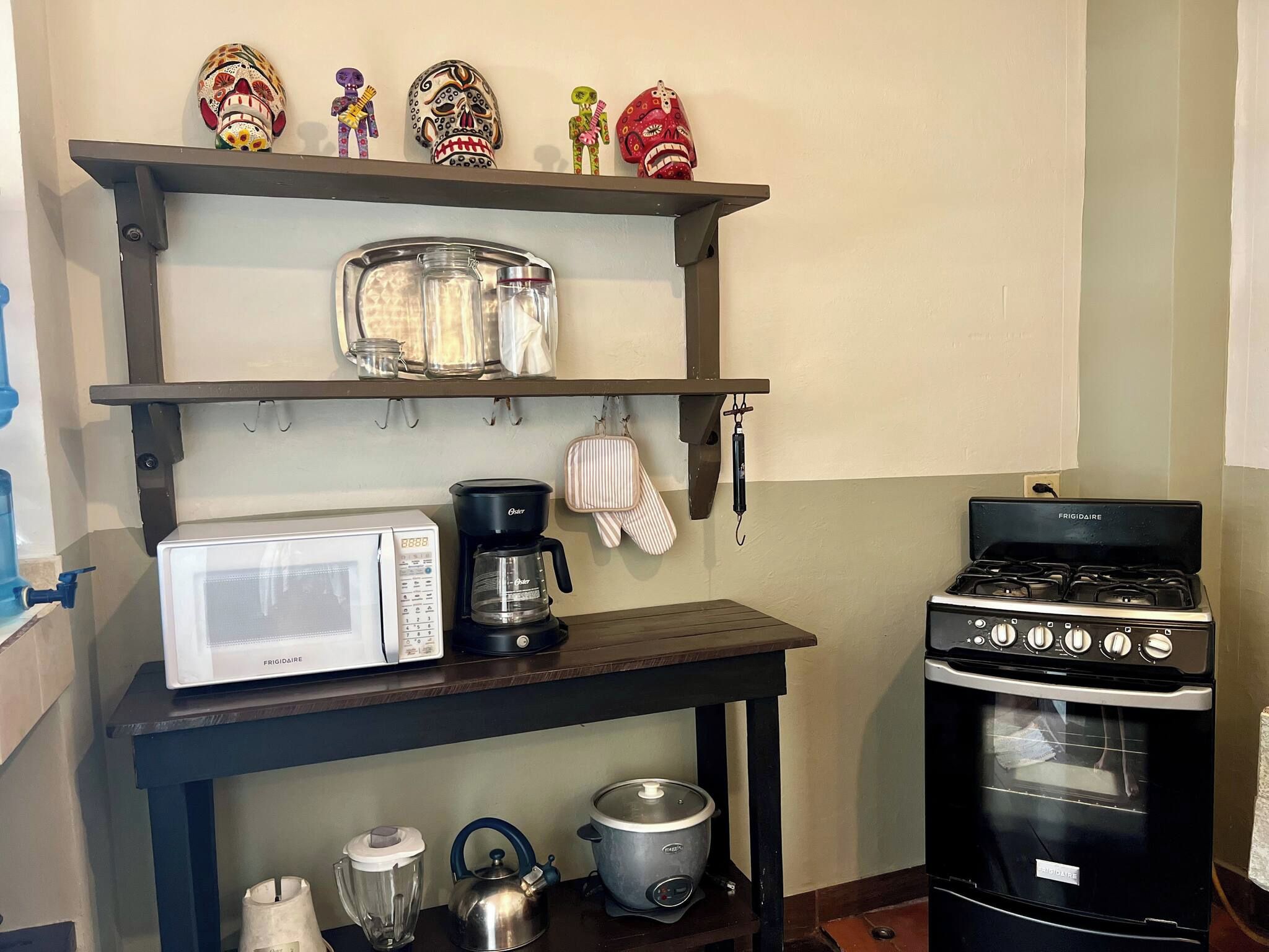 Une cuisine équipée d’un four à micro-ondes Frigidaire, d’une machine à café, d’une bouilloire, d’un cuiseur à cuisson lente et d’une cuisinière.