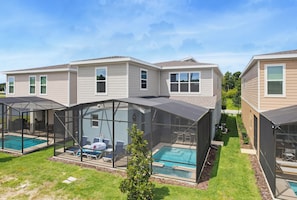 Ein Wohnhaus mit Swimmingpool, überdachten Terrassen und einem gepflegten Rasen.