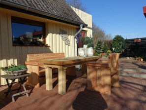 An outdoor wooden table and benches, a window with a view, and potted plants. - Holiday Apartment With 2 Bedrooms (Kappeln)