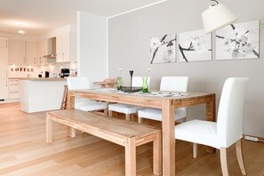 A modern kitchen with white cabinets and a wooden island. - House by the sea, Apartment 14 (Timmendorfer Strand)