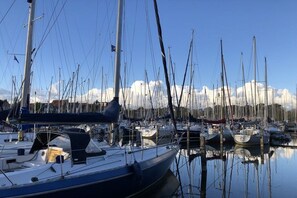 A marina with multiple boats docked, calm water, and a clear sky. - Holiday home Holland North (Medemblik)