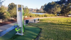 An outdoor exercise area with a bench, a rowing machine, and a pull-up bar. - The Wattle House - Your Home Away from Home (Wattle Grove)
