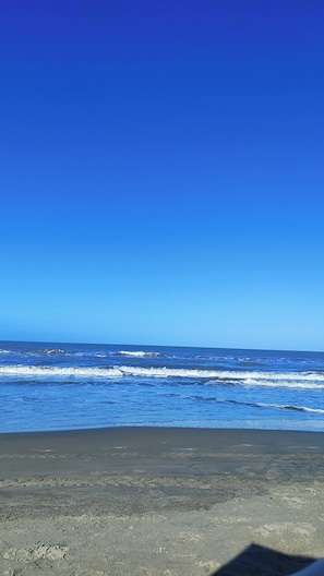 Ein Strand mit Wellen und blauem Himmel.