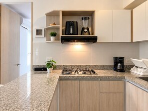 A modern kitchen with a gas stove, a coffee maker, and a built-in blender. - Experience Cartagena History Caribbean Flavors and Relaxation in Serena del Mar (Cartagena Province)