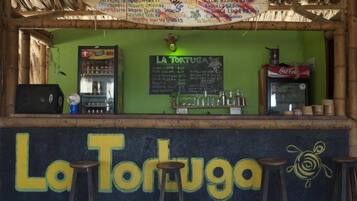 Un bar appelé «
La Tortuga
», avec un tableau noir servant de menu, un réfrigérateur et un distributeur de Coca-Cola.