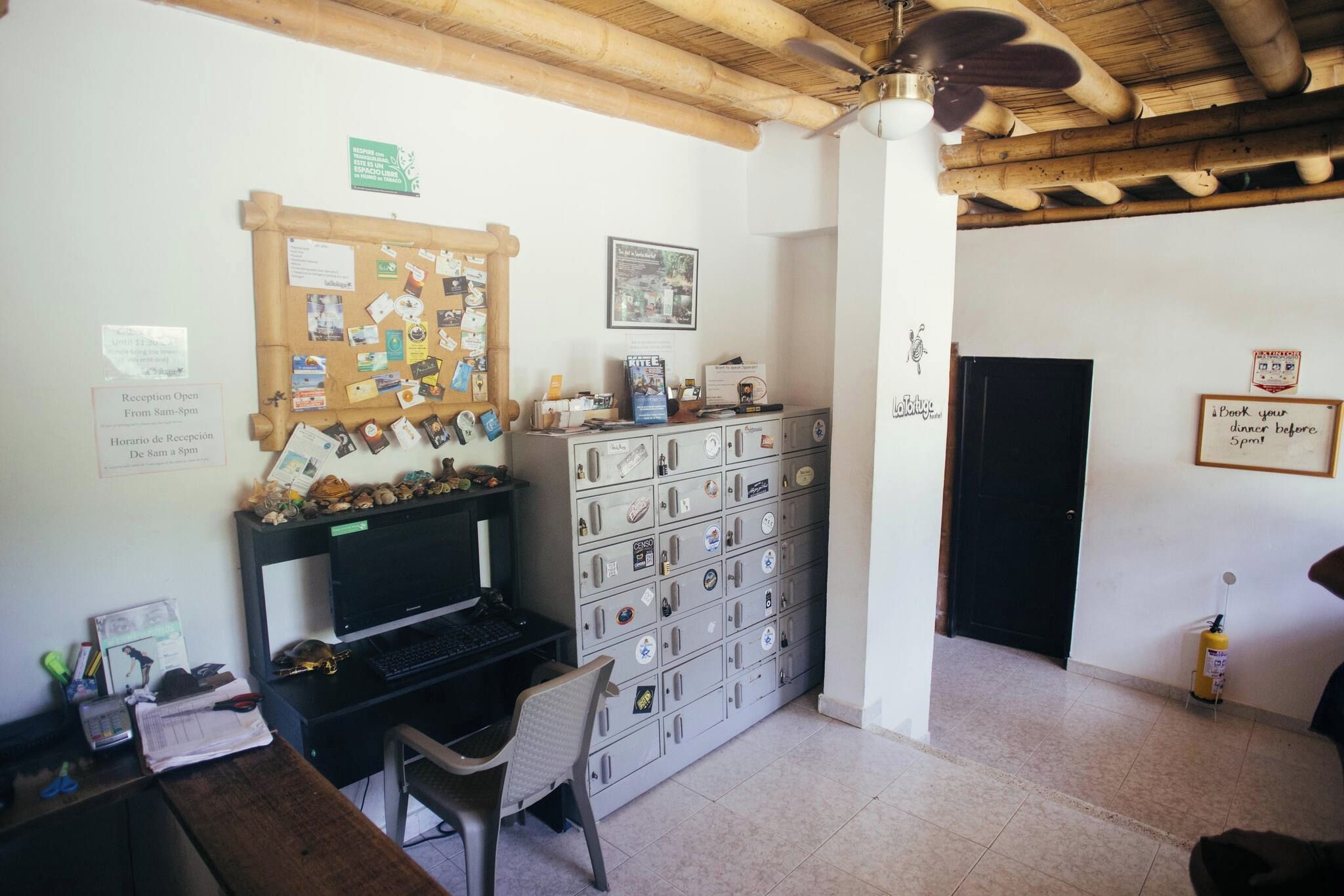 A room with a computer desk, a filing cabinet, and a reception area.