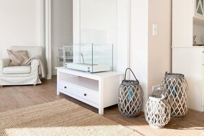 A modern living room with a white sofa, a glass-top coffee table, and decorative woven lamps. - Holiday home with 3 bedrooms (Timmendorfer Strand \/ Niendorf)