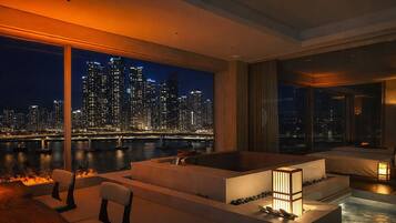 A modern interior with a large window overlooking a cityscape at night.