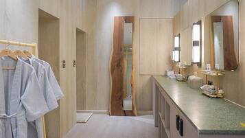 A modern bathroom with a vanity, mirrors, and a towel rack.