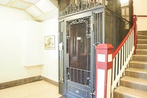 A staircase with a red handrail and a metal gate with a decorative design. - Villa Démory Apartment 22 (Timmendorfer Strand)