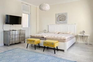 A bedroom with a bed, a television, a dresser, and a small table. - Villa Démory Apartment 22 (Timmendorfer Strand)