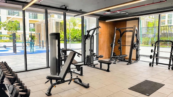 Ein Fitnessraum mit Trainingsgeräten, großen Fenstern und Blick nach draußen.