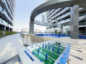 Ein modernes Gebäude mit Poolbereich, inklusive Tischfußball und Wasserspiel.