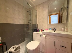 A modern bathroom with a glass shower enclosure, a toilet, and a vanity with a mirror. - ☀️ El Rincon S&E – Your little corner of paradise between golf, the beach, and the sun (San Miguel de Salinas)