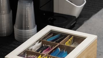 Une boîte en bois étiquetée « THÉ », comportant des compartiments contenant divers crayons de couleur.