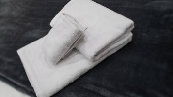 Une serviette blanche pliée sur une surface sombre.