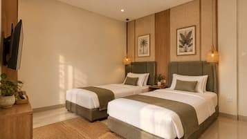 A hotel room with two beds, a wooden cabinet, a television, and wall-mounted artwork.