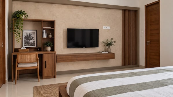 A bedroom with a bed, a desk with a chair, a television, and a wardrobe. - Awi House (Jimbaran)