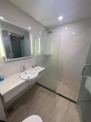 A modern bathroom with a glass shower enclosure, a white sink, and a mirror above the sink. - Silver Quarter Hanoi Hotel (Hanoi)