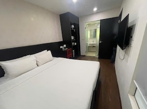A hotel room with a large bed, a TV mounted on the wall, and a bathroom visible through an open door. - Silver Quarter Hanoi Hotel (Hanoi)