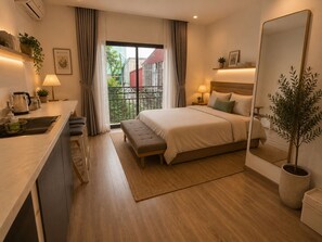 Quarto de hotel moderno com cama, mesa de cabeceira, abajur e um espelho grande.