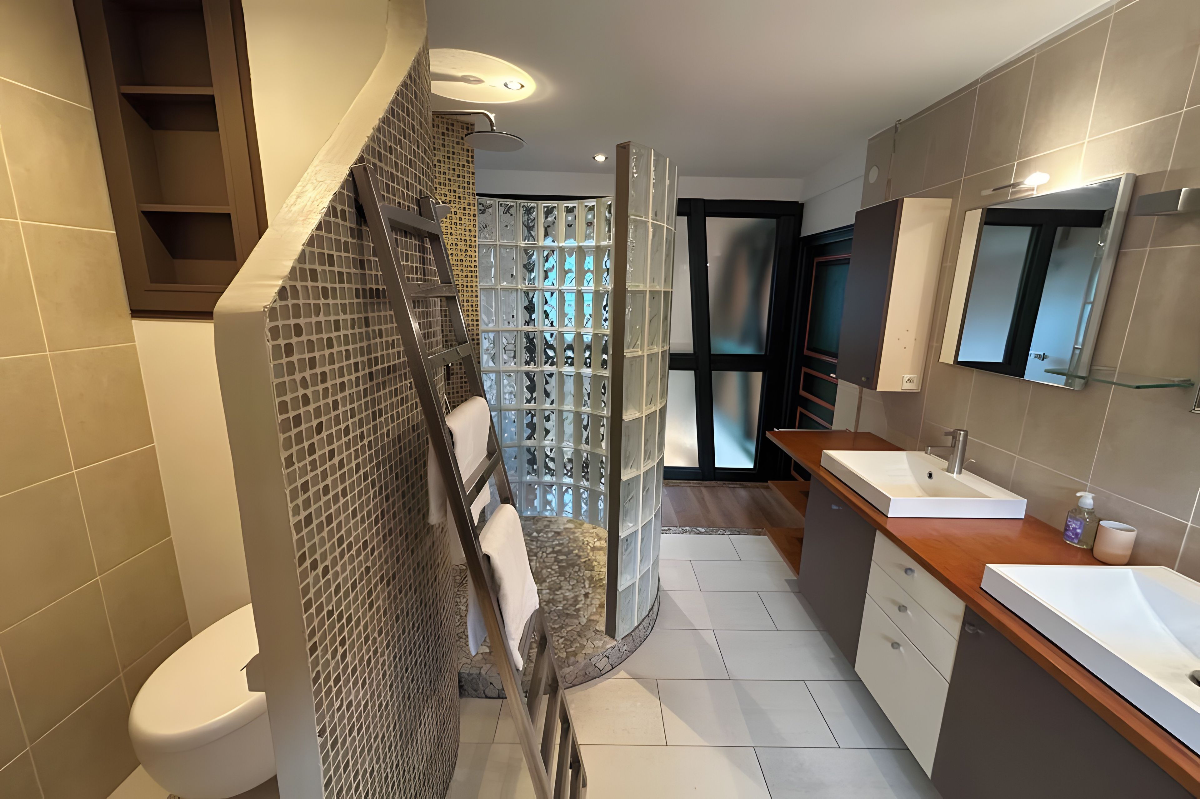 Een moderne badkamer met een douche, toilet en wastafel.