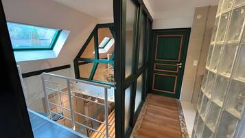 Un intérieur moderne agrémenté d’une verrière, d’un escalier et d’une porte dotée d’un cadre vert.