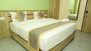 Een hotelkamer met een houten bedframe, witte beddengoed en een spiegel aan de muur.