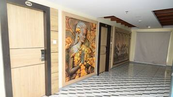 A hallway with wooden doors, a tiled floor, and a mural on the wall.