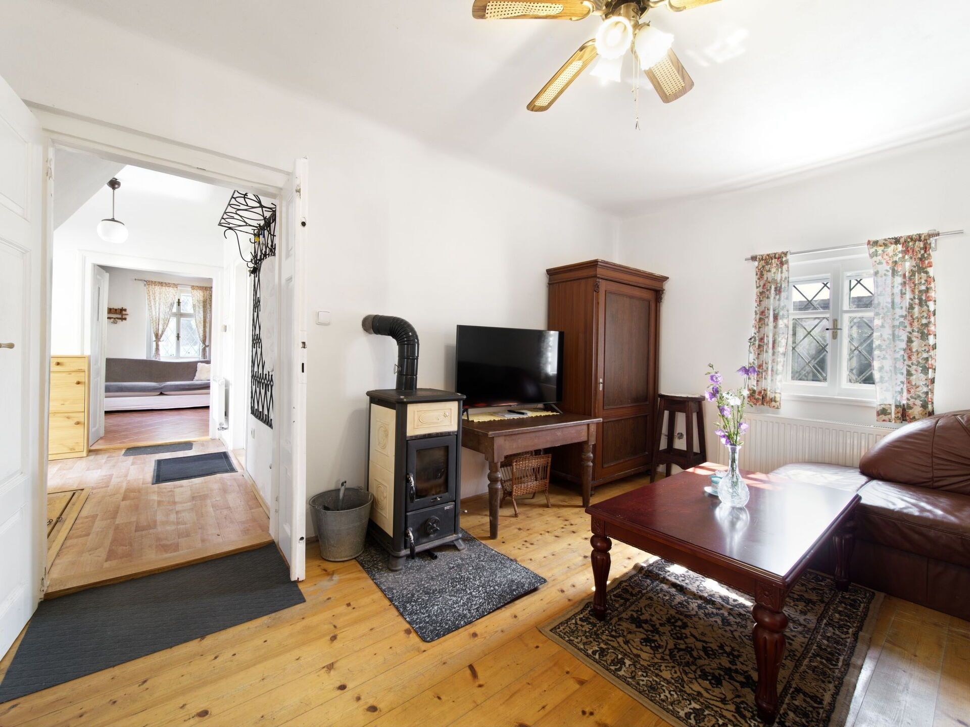 Una sala de estar con chimenea, televisor, aparador de madera y sofá.