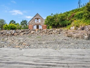 A stone building with a triangular roof, situated on a rocky terrain with a clear sky. - Beautiful private villa for 6 people with WIFI and patio (Isle Of Skye)