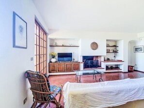 Ein Wohnzimmer mit Fernseher, Kamin und Essbereich.