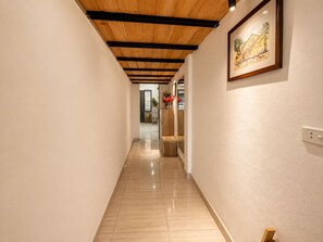 A hallway with a wooden ceiling, a framed picture on the wall, and a tiled floor. - Old Quarter 2Brs Apt . Big Balcony . FreeLaunry by Anamoi (Hà Nội)