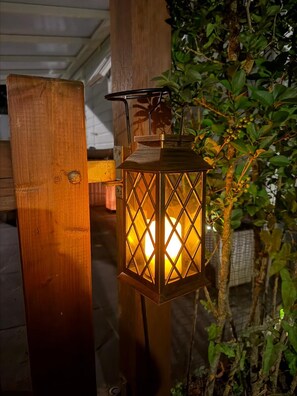 A lantern with a candle inside, mounted on a wooden post. - Chalet Lebensfreude – A Getaway by the Water (Lathum)